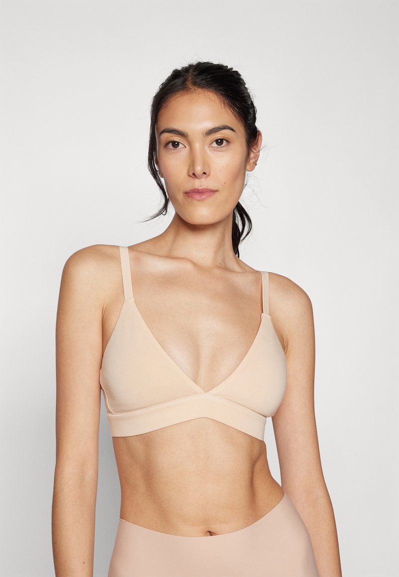 Bralette nudo senza cuciture con scollatura a V, spalline regolabili e una texture morbida ed elastica per comfort e un look aderente.
