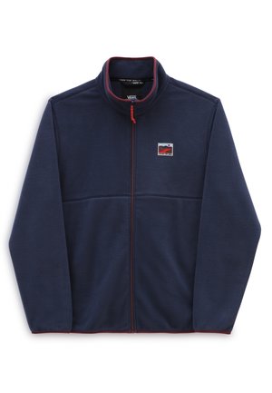 Veste polaire bleu marine avec fermeture éclair intégrale sur le devant, col montant, bordure rouge et un petit patch logo rectangulaire sur la poitrine gauche.