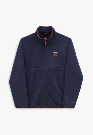 Veste polaire bleu marine avec fermeture éclair intégrale sur le devant, col montant, bordure rouge et un petit patch logo rectangulaire sur la poitrine gauche.