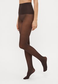 Brune, gjennomsiktige tights med høy midje-design og en glatt tekstur. Justerbar midje og forsterket tådetalj. Egnet for ulike stiler.