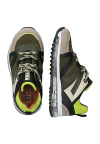 Sportliche Sneaker in Olivgrün und Beige aus Mesh, mit schwarzen Akzenten, reflektierenden Schnürsenkeln und einer weißen Sohle mit transparenten Luftpolstern.