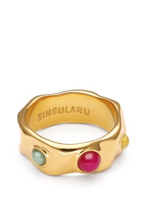 Goldener Ring mit unregelmäßiger Form, besetzt mit grünen, roten und gelben runden Steinen und dem Wort "SINGULARU" eingraviert innen.