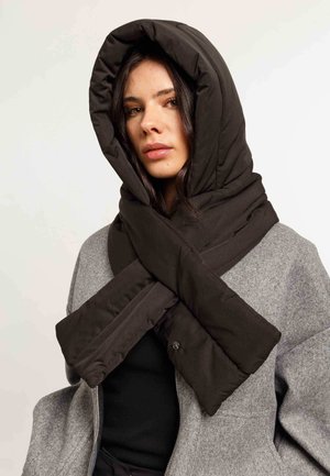Black padded scarf with a large hood, wrapped in an X shape around the neck, paired with a gray coat. Smooth texture, quilted design.