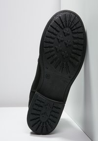 Black rubber sole with a textured grip pattern, featuring a rounded shape, and marked with size 37 for fit identification.