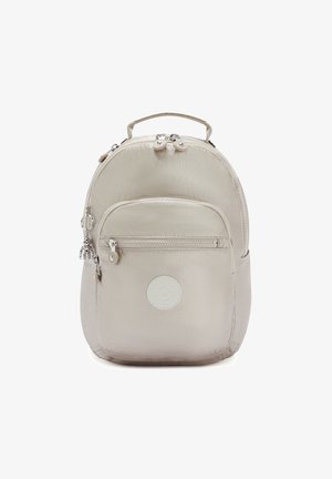 Beige nylon rugzak met een ronde vorm, voorzien van een voorzak met rits, een handvat bovenop en een logopatch. Accenten van zilverkleurig hardware.