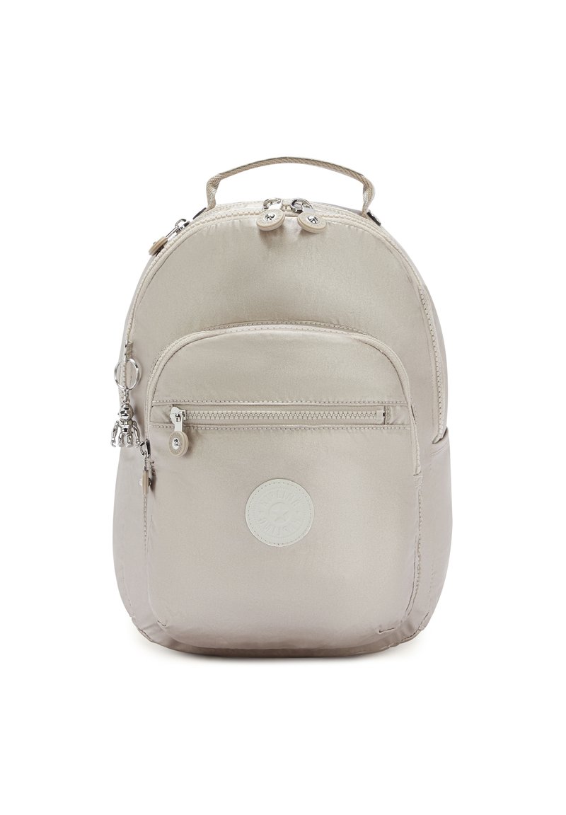 Zaino in nylon beige dalla forma arrotondata, dotato di una tasca frontale con zip, maniglia superiore e patch con logo. Finiture in hardware argentato.