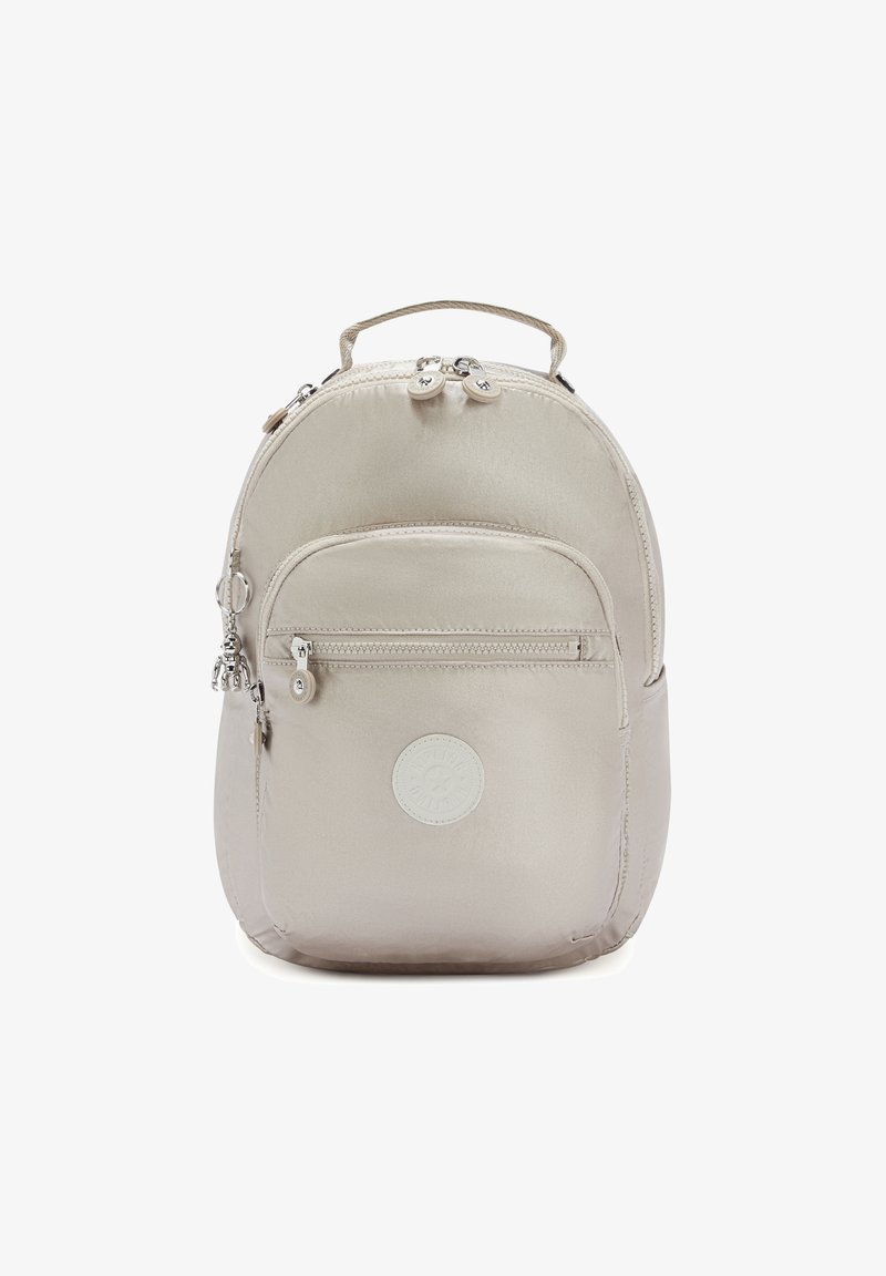Zaino in nylon beige dalla forma arrotondata, dotato di una tasca frontale con zip, maniglia superiore e patch con logo. Finiture in hardware argentato.
