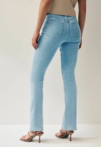 Next SUPER SOFT PETITE - Šiek tiek platėjantys apačioje džinsai - bleach blue