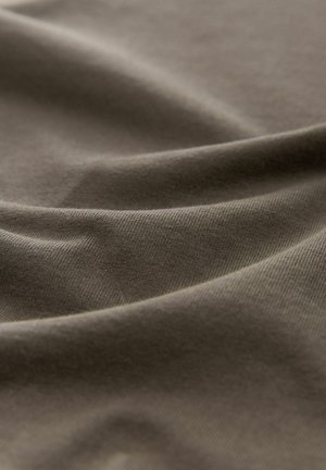 Tessuto di cotone in un verde oliva tenue, che mostra una texture morbida e liscia con pieghe e grinze sottili.
