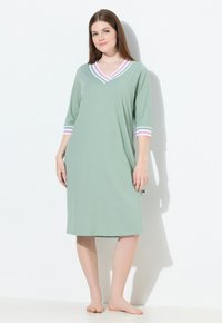 Camicia da notte verde chiaro con scollatura a V, maniche 3/4 e accenti a righe rosa e bianche sul colletto e sulle maniche. Tessuto morbido, lunghezza al ginocchio.