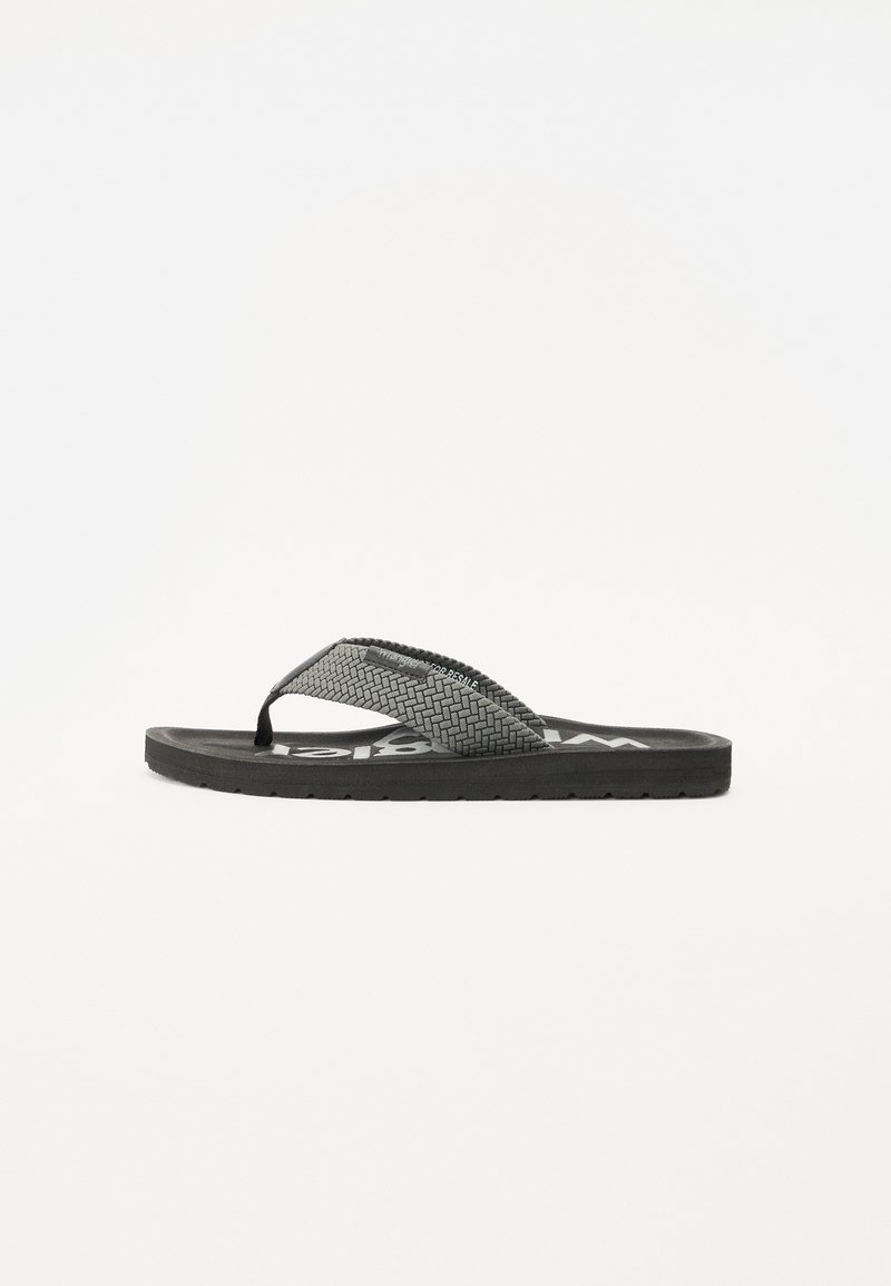 Svart flip-flop sandal med en teksturert stropp og flat såle. Stroppen har et flettet mønster og har en logo på fotsengen.