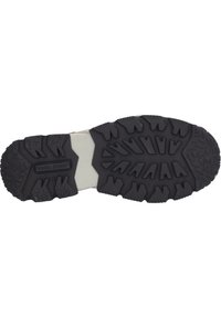 Suola di scarpa in gomma nera con scanalature profonde, caratterizzata da motivi triangolari e rettangolari, con una sezione centrale liscia e accenti bianchi.