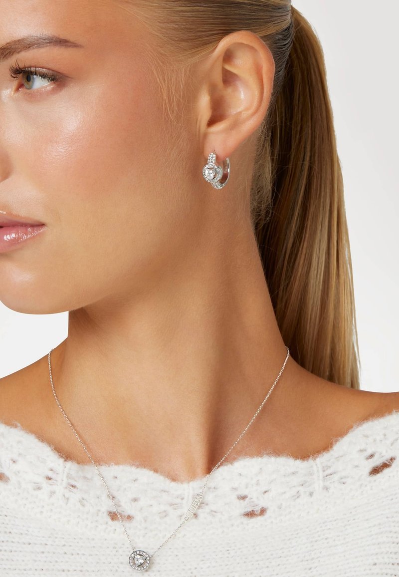 Zilveren luisterhangers met een kristal in een druppelontwerp, met heldere accenten. Delicaten zilveren ketting met een ronde hanger.