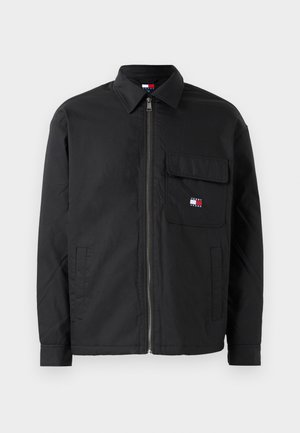 Giubbotto nero con zip e colletto, tasca frontale con pattina che presenta un piccolo logo Tommy Jeans rosso, bianco e blu, e due tasche laterali.
