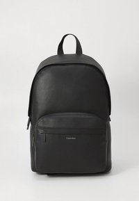 Black leather backpack with a textured finish, rounded shape, top handle, and front zip pocket featuring branded detail.