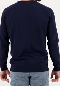 Mörkblå stickad tröja med långa ärmar, ribbad mudd och nederkant, med raglanaxelsömmar och en liten logotyp på bakhalsen.