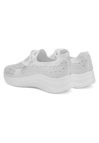 Coppia di sneaker bianche lavorate a maglia con decorazioni di strass, lacci bianchi e suole spesse e testurizzate, viste da un angolo laterale-posteriore.