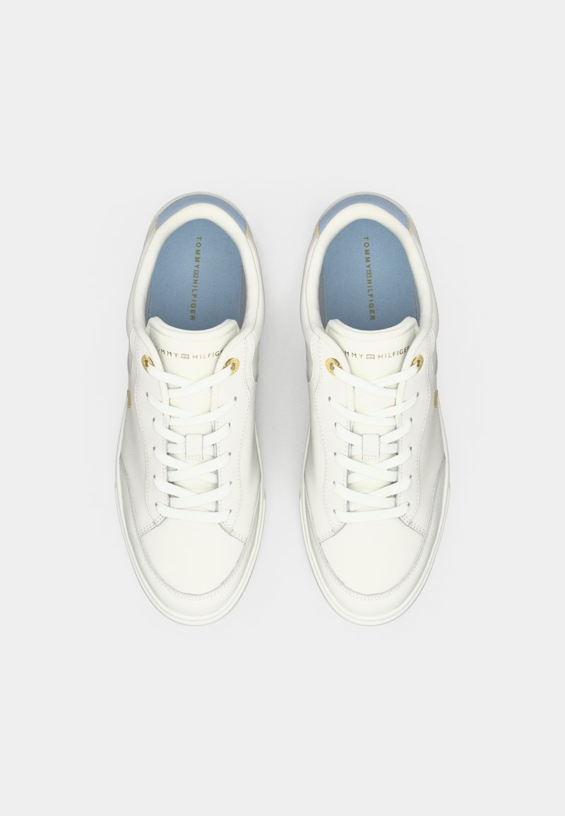 Weiße Ledersneaker mit niedrigem Profil, flachen Schnürsenkeln, goldenen Akzenten und einem hellblauen Innenfutter mit dem Markennamen.