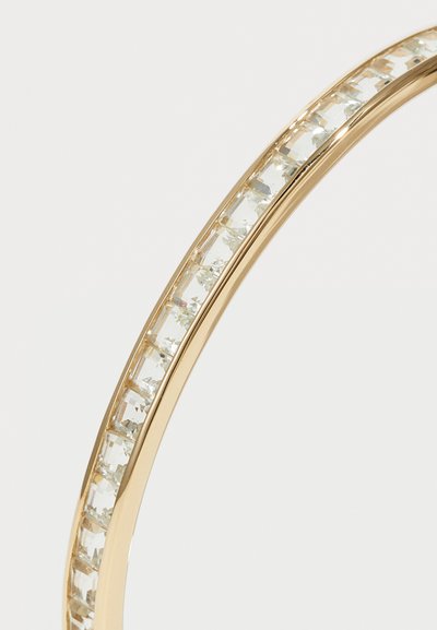 Aranyszínű karkötő, amely egy sor tiszta, téglalap alakú kristályt tartalmaz egy sima, fényes sávban, kiemelve annak tükröződő felületét.