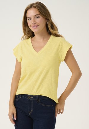 Yellow V-neck t-shirt with short sleeves, made from textured fabric. Paired with dark blue jeans, showing a casual fit.