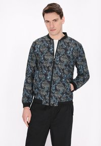 Sort bomberjakke med blomsterprint i nuancer af blå og beige, lynlåslukning, ribbede manchetter og kanten, letvægtsstof.
