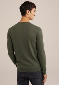 Mörkgrön stickad tröja med rund halsringning, långa ärmar och en något figursydd design; strukturerad tyg med ribbade ärmslut och nederkant.