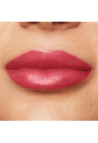 Rouge à lèvres mat sur des lèvres pulpeuses, avec une couleur rose moyenne et une texture lisse, mettant en valeur une forme bien définie contre un teint de peau naturel.