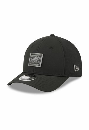 Schwarze verstellbare Baseballkappe mit einem erhabenen quadratischen Logo-Patch eines Adlers auf der Vorderseite und einem Markenlogo an der Seite.