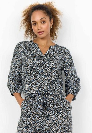 Sort blomstret bluse med v-udskæring, lange ærmer med manchetter og snørre i taljen. Stofen har en glat tekstur med små blå og beige blomsterprints.