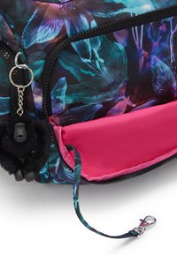 Floral-patterned bag featuring a dark, glossy finish with blue and purple accents, hot pink lining, and a black plush monkey zipper charm.
