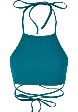 Le crop top halter côtelé en teal présente un design ajusté avec des bretelles à nouer réglables et un dos croisé. Texture lisse sur l'ensemble.