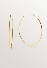 Pendientes de aro de oro con un diseño circular delgado. Superficie lisa y pulida; elegancia discreta en metal ligero.