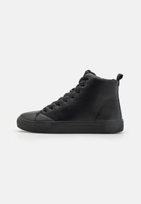 Zapatillas altas negras de cuero liso, con puntera redonda, suela de goma plana y cierre de cordones. Diseño minimalista sin patrones.