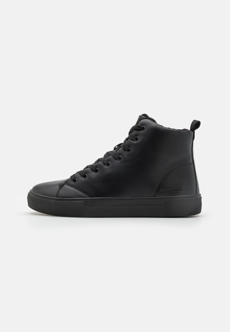 Zapatillas altas negras de cuero liso, con puntera redonda, suela de goma plana y cierre de cordones. Diseño minimalista sin patrones.