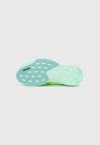 Schuhsohle aus leicht mintgrünem Gummi mit einer strukturierten Oberfläche und einem Muster aus länglichen Löchern für Traktion.