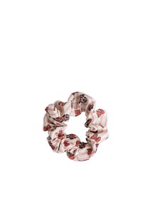 Scrunchie floreale in strisce rosa e crema. Realizzato in morbido tessuto, con fiori rossi delineati in nero e una texture arricciata.