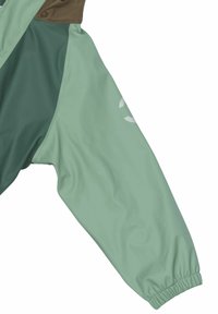 Vandtæt jakke i lys grøn og mørk grøn, med elastiske manchetter, en trykknapklap og et logo på ærmet.