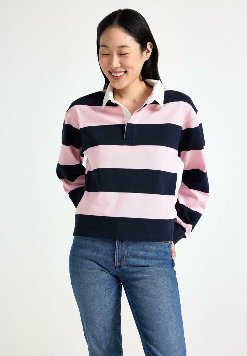 Langærmet polo-shirt med horisontale navy- og lyserøde striber, en hvid krave, afslappet pasform og ribbede manchetter. Sammen med denim jeans.