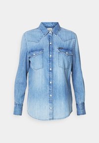 Světle modrá džínsová košile s dlouhými rukávy, špičatým límcem, dvěma náprsními kapsami a knoflíky vpředu. Obsahuje akcenty žlutého prošívání.