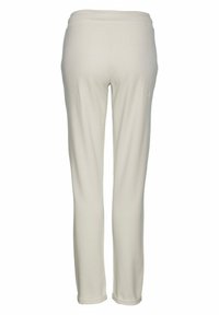 Slim-fit, broek met elastische tailleband in lichtbeige. Gemaakt van zachte stof met een gladde textuur en zonder zichtbare patronen of hardwaredetails.