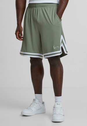 Olivgröna träningsshorts med resårmidja, vita sidostråkar och en vit logodetalj. Har två sidofickor.