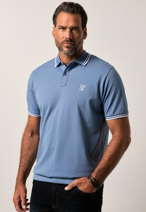 Camisa polo azul claro con cuello y puños a rayas blancas, con un logo bordado en el pecho. Fabricada en tejido de algodón texturizado.