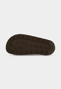Semelle d'une chaussure marron avec des motifs de semelle profonds et le nom de la marque "BOSS" ainsi que la taille "37" embossés près du talon.