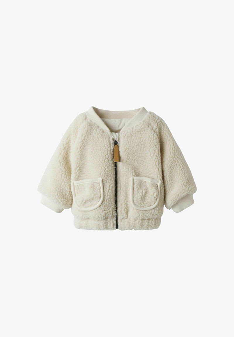 Kreemivärvi fliisjakker, millel on luku ees, soonikkoes varrukad ja kaks esikotti, pehme tekstuuriga ja vabalt istuv.