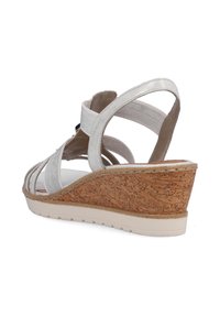 Sandales à talons compensés avec tige en tissu métallique argenté et brides élastiques. Plateforme en texture liège, semelle blanche, design ouverte au bout.