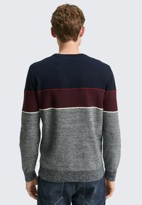 Herren Strickpullover mit navy, burgunderrot und grauen Streifen. Gerippter Kragen und Bündchen. Strukturierter Stoff mit kontrastierenden Farben und Mustern.