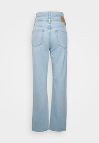 Jeans de denim azul claro com um ajuste relaxado, apresentando uma cintura alta, dois bolsos traseiros e um logo em couro na cintura.