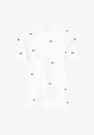 Balta medvilnės marškinėliai su juodais kaspinų raštais išmėtytais ant audinio, trumpomis rankovėmis ir apvalia iškirpte.