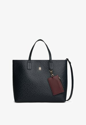 Czarna torebka na ramię z teksturowanej tkaniny, z podwójnymi uchwytami, złotym logo i odpinanym bordowym etui na karty, przyczepionym złotym łańcuszkiem.