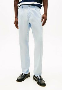 Helle blaue, leichte Hose mit glatter Textur, schmaler Passform und einem Knopfverschluss vorne. Verfügt über ein traditionelles Taschendesign.